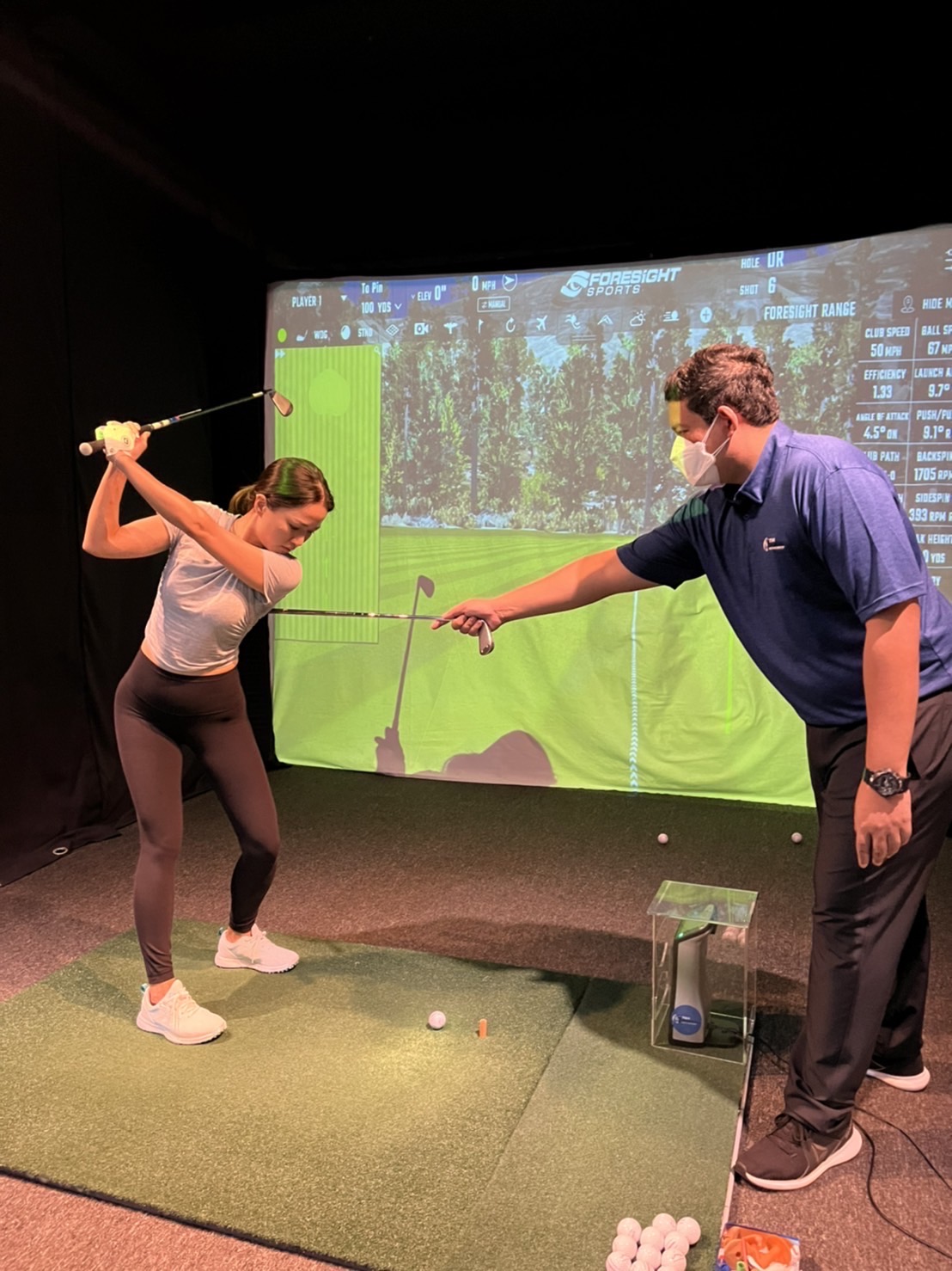 A PGA professional coaching a student at the academy